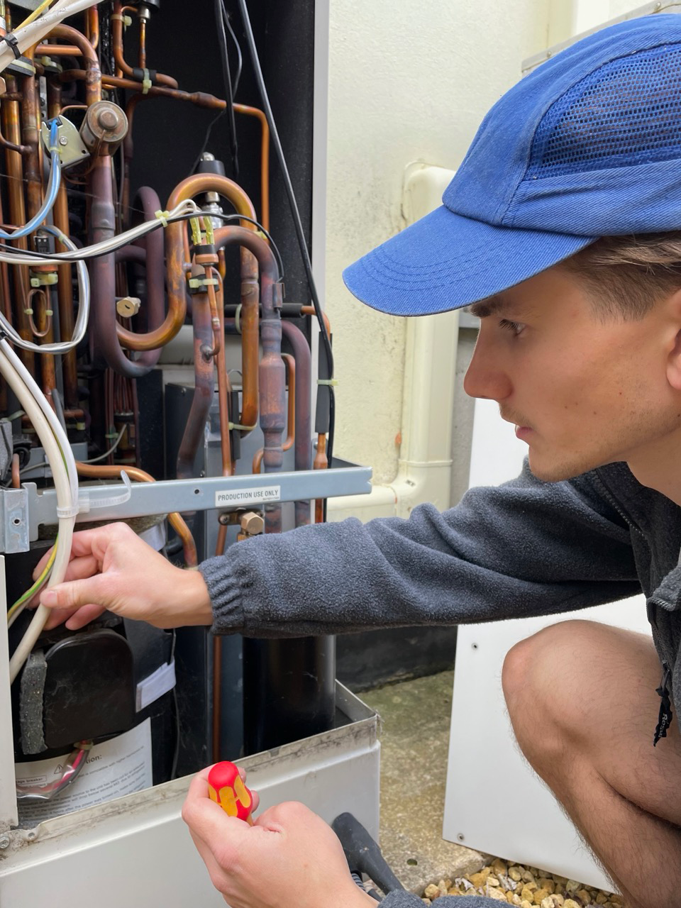 Jack from Dr Heat Pump working on an open air source heat pump